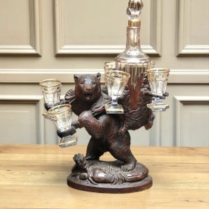 A Swiss Carved Linden Wood Black Forest Bear Liqueur set with gilded decanter and glasses circa 1900